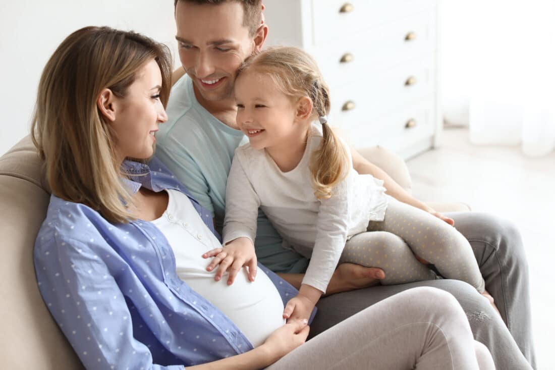 Young,Pregnant,Woman,With,Her,Family,At,Home