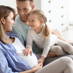 Young,Pregnant,Woman,With,Her,Family,At,Home