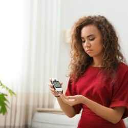 Young,African american,Woman,Using,Digital,Glucometer,At,Home.,Diabetes,Control