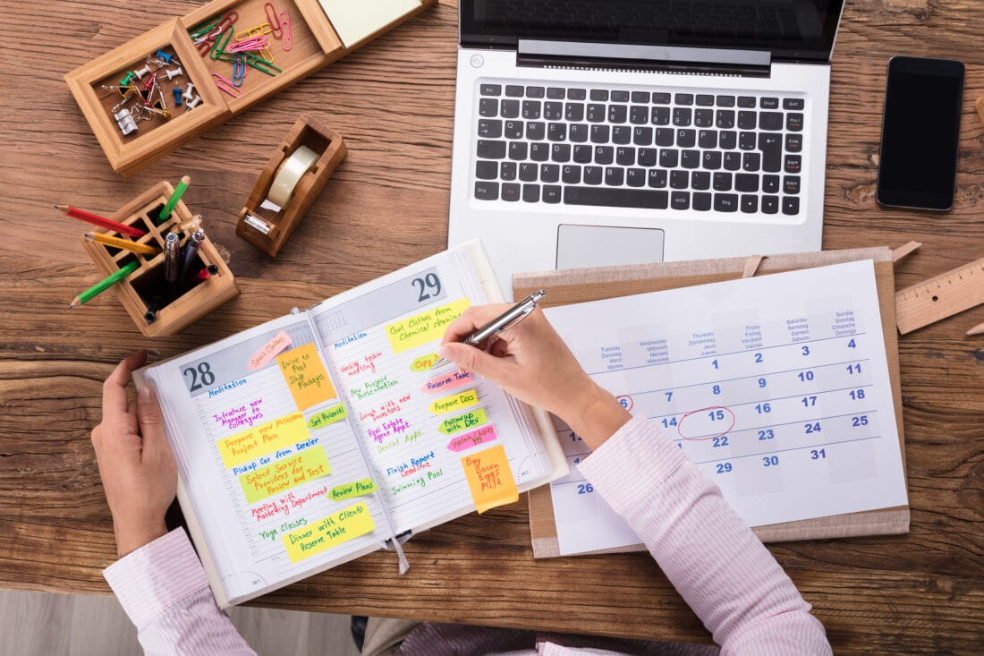 Close up,Of,Businesswoman,Writing,Schedule,In,Calendar,Diary,On,Desk