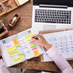 Close up,Of,Businesswoman,Writing,Schedule,In,Calendar,Diary,On,Desk
